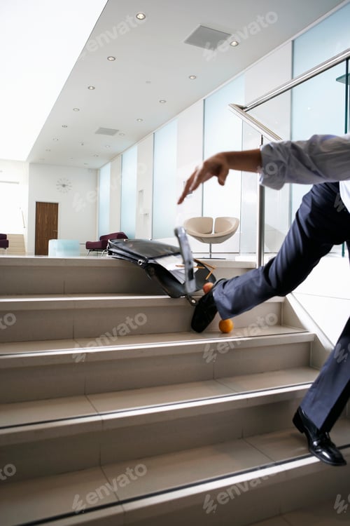 Preview: Businessman Falling Down Steps In Office Lobby Seen From Low Angle.