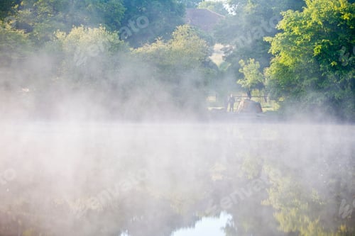 Preview: Wide Shot Of A Fisherman Standing Beside His Tent At A Distance In Front Of A Misty Lake