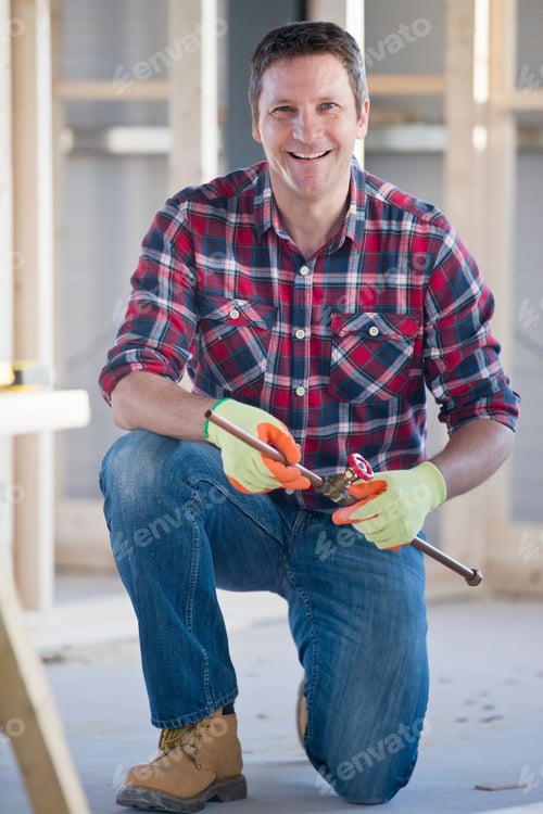 Preview: Portrait Of Plumber Working With Pipes On Indoor Construction Site