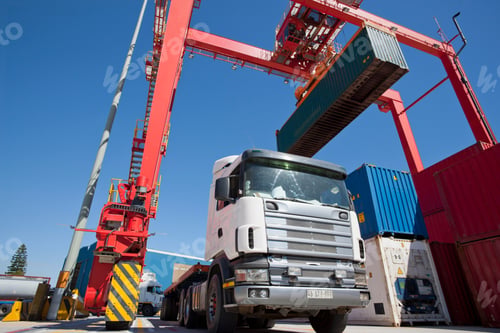 Preview: Low Angle Shot Of A Lorry Being Loaded With A Container By A Gantry Crane