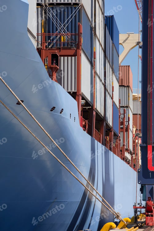 Preview: Vertical Shot Of The Side Of A Container Ship With Cargo Containers Moored At A Commercial Dock.