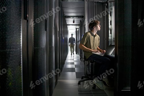 Preview: A Technician Is Checking The Data Center With His Laptop And His Colleague Is Walking On The Floor