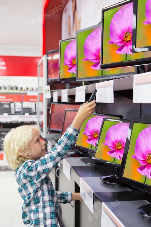 Preview: A Young Boy Holding A Remote Control And Pointing It At The Televisions In An Electronics Store.