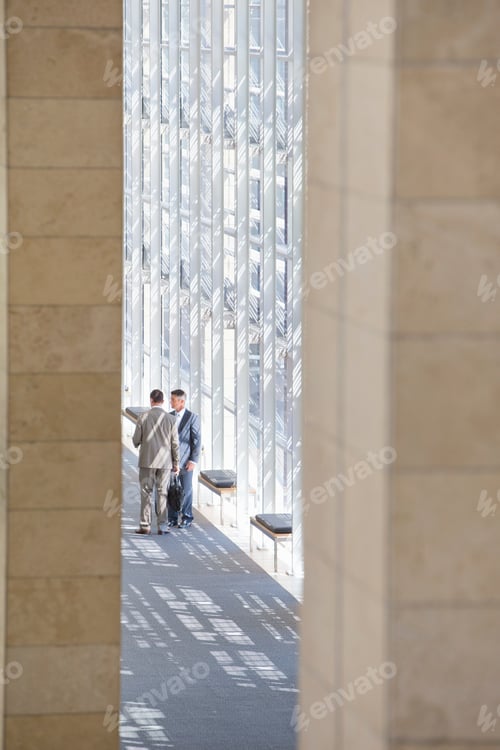 Visualização: Empresários falando no saguão de um escritório moderno