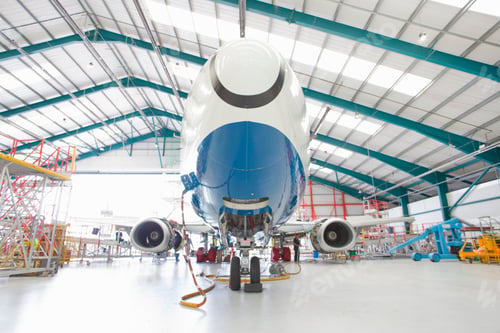 Preview: Low-Angle Wide Shot Of The Front Of A Passenger Jet In A Hangar.