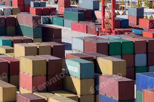 Preview: Multicolored Cargo Containers Stacked At A Commercial Dock With A Crane In The Background.