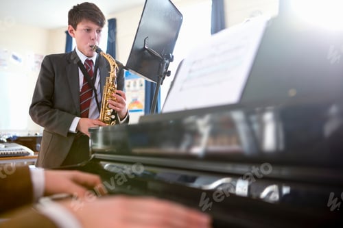 Visualização: Estudante do ensino médio lendo partituras e tocando saxofone com um professor de música tocando piano