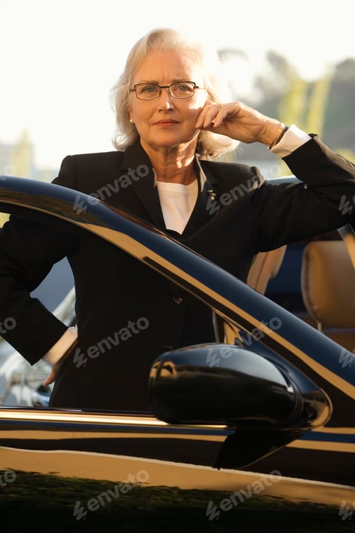 Preview: Portrait Of Senior Businesswoman With Car At Camera
