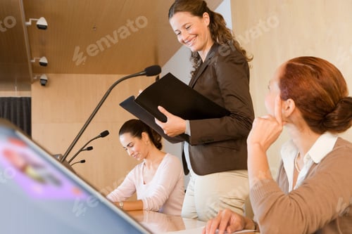 Preview: Close-Up Three Quarter View Of Businesswoman Talking In Conference Room Holding Folder With