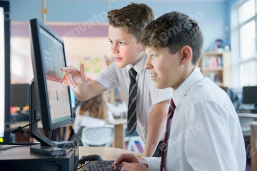 Preview: Close Up Of Schoolboys In Private School Uniform Sharing Computer And Talking In The Computer Lab