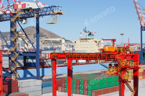 Preview: Cranes And Stacked Cargo Containers At A Commercial Dock With A Container Ship In The Background.