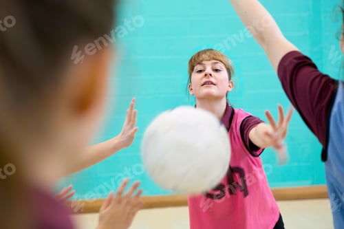 Preview: High School Student Throwing A Netball During A Match In A Gym Class.