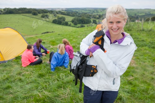 Preview: Girl With A Backpack Wearing A White Windcheater Smiling At The Camera With A Group Of Friends