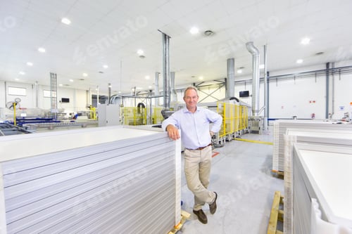 Preview: Portrait Of A Smiling Businessman Standing In A Factory Leaning On The Solar Panels