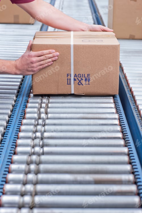 Preview: Close-Up Vertical Shot Of The Hands Of A Worker Packing A Box On Conveyor Belt At A Distribution