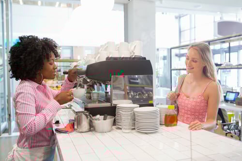 Preview: Smiling Waitress Preparing Coffee For A Customer In A Coffee Shop