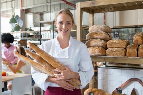 Preview: Smiling Baker Holding Baguettes In A Bakery