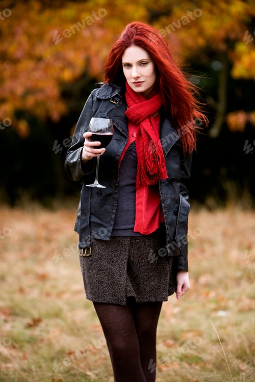 Preview: A Young Woman Holding A Glass Of Red Wine