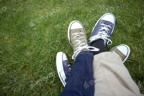 Preview: A Close-Up Shot Of Couple Entwined Sneakers Over Grass.