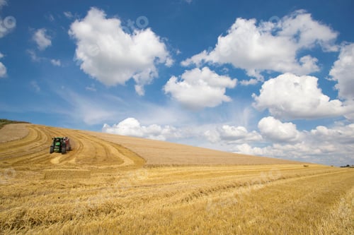 Preview: Extreme Wide Shot Of A Tractor Baling Straw Over A Rural Field On A Sunny Day.
