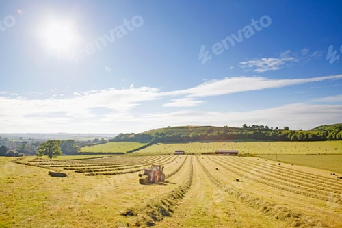 Preview: Wide Shot Of A Tractor Baling Hay In The Field
