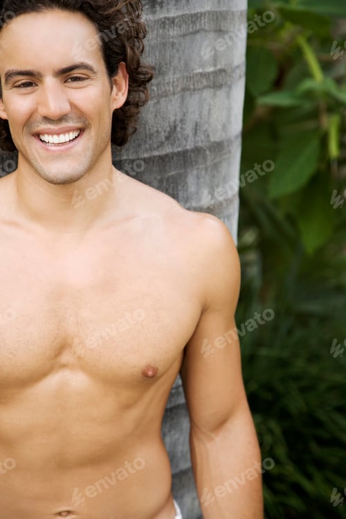 Preview: Portrait Of A Toned Muscular Man Standing In A Garden Wearing White Linen Trousers