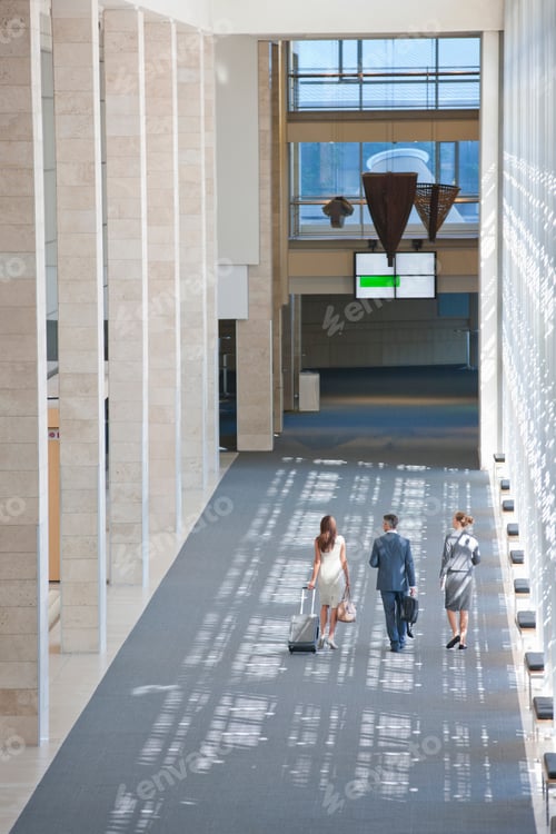 Preview: Vertical Shot Of Business Employees Walking Together In The Lobby Of A Modern Office Holding