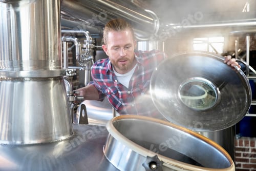 Preview: Portrait Of A Brewery Worker Checking Fermentation Process In Steel Vat