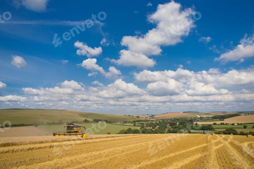 Preview: Extreme Wide Shot Of A Combine Harvester Reaping Wheat In A Rural Field On A Cloudy Day.