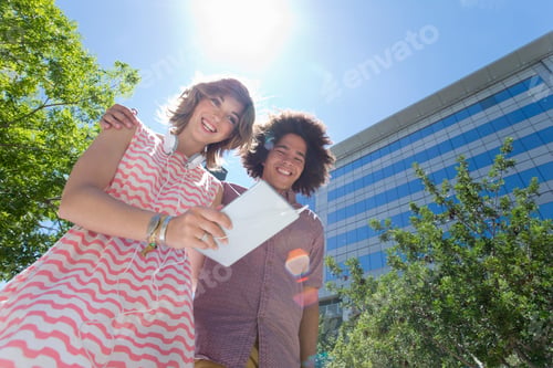 Preview: Smiling Young Couple Walking Around In The City Together And Using A Digital Tablet