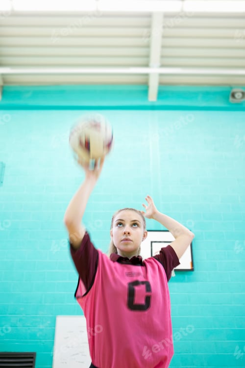 Preview: Focused High School Student Playing Netball In Gym Class