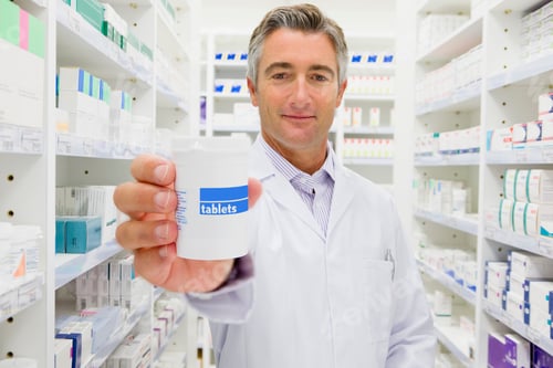 Preview: Pharmacist Holding Bottle Of Prescription Medication In Pharmacy