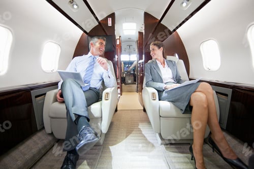 Preview: A Businessman And A Businesswoman Talking While Sitting In A Private Jet