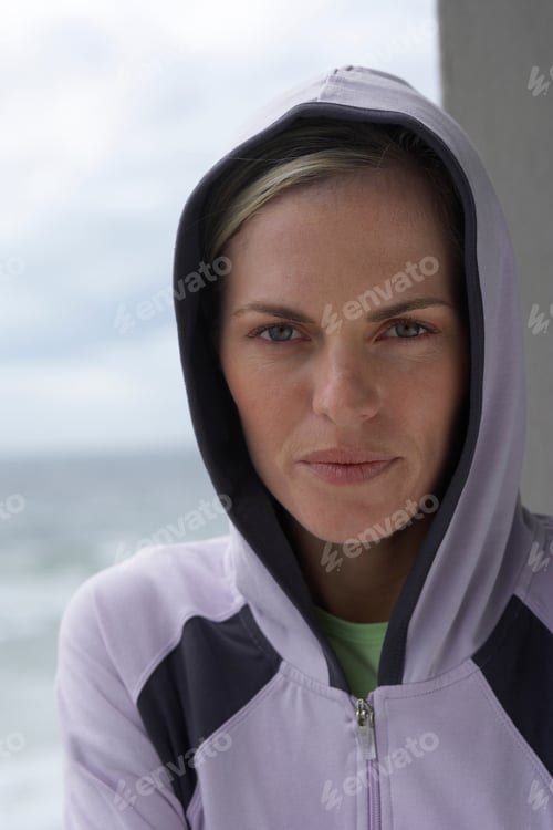 Preview: Vertical Portrait Shot Of A Woman In A Hoodie With The Sea In The Background.