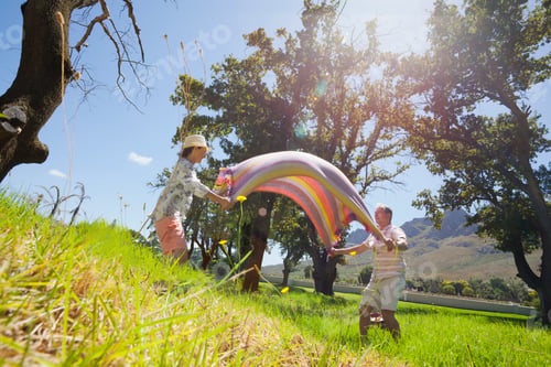 Preview: Wide Shot Of An Elderly Couple Laying Picnic Blanket In A Field.