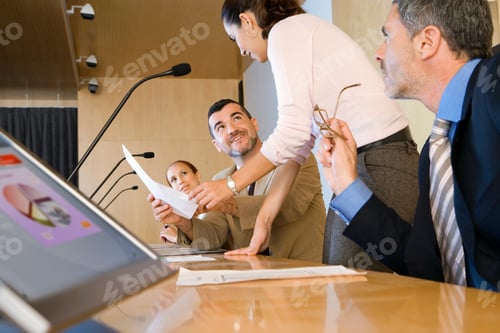 Preview: Close-Up Three Quarter Profile View Of A Businesswoman Discussing A Document With Colleagues In A