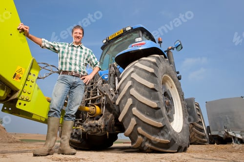 Preview: Farmer Standing Beside A Tractor With A Farming Equipment Attached