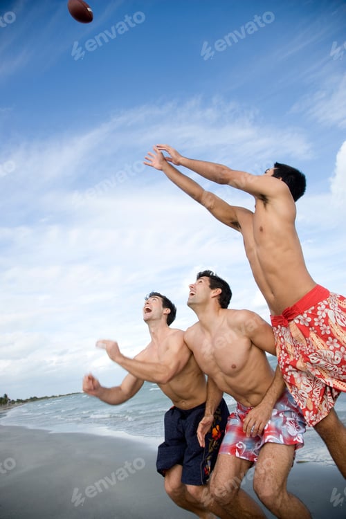 Preview: Three Young Men Playing With A Ball On A Beach