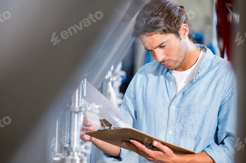 Preview: Worker Checking Reports On A Notepad In A Brewery