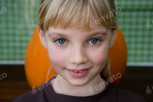 Preview: Little Girl Standing In Front Of An Orange Hallowe'En Pumpkin