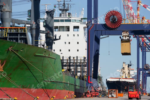 Preview: Wide Shot Of A Container Ship Unloading Cargo Containers At A Commercial Dock.