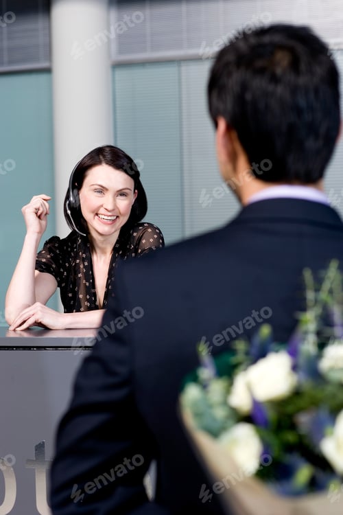 Preview: Businessman With Bouquet Of Flowers Being Greeted By Office Receptionist