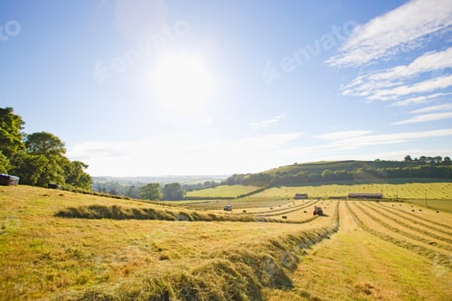 Preview: Wide Shot Of A Vast Field With A Tractor Baling Hay