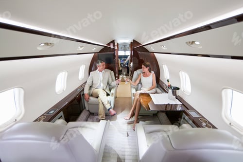 Preview: Smiling Couple Making A Toast With Champagne Glasses In A Private Jet