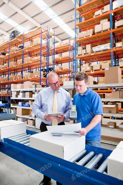 Preview: Supervisor With A Digital Tablet Watching Worker Scan Paperwork And A Box At The Production Line Of