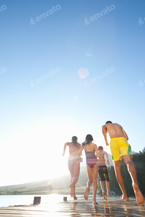 Preview: Low Angle Shot Of A Family Running On A Wooden Dock At A Lake