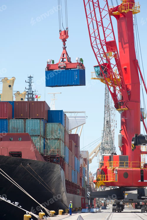 Preview: Cargo Being Unloaded From A Ship Anchored At A Dock