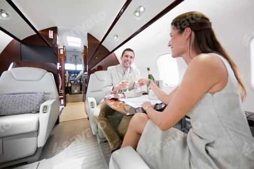 Preview: Smiling Couple Drinking Champagne In A Private Jet