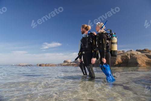 Preview: Couple In Wetsuits Going Ocean Scuba Diving From Beach