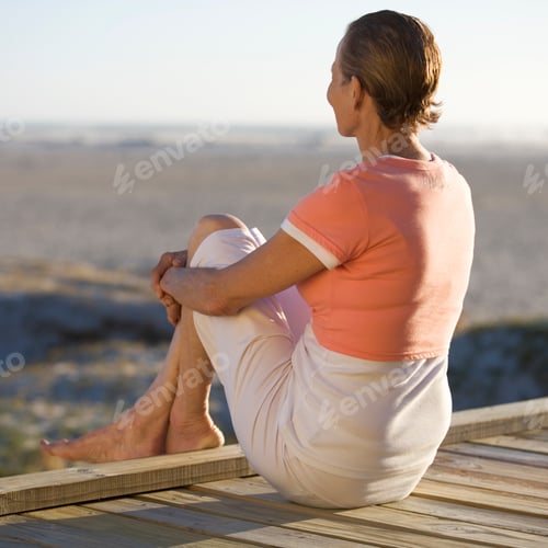 Preview: A Mature Woman Sitting On A Boardwalk